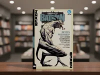 Absolute Batman Vol 3 comic book on a table in a blurred bookstore.