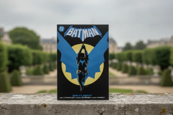 Batman Vol 1 Daylight comic on a stone ledge in a lush French garden.