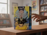 A person's hand reaching for "The Batman Family Year One Box Set" in a comic shop.